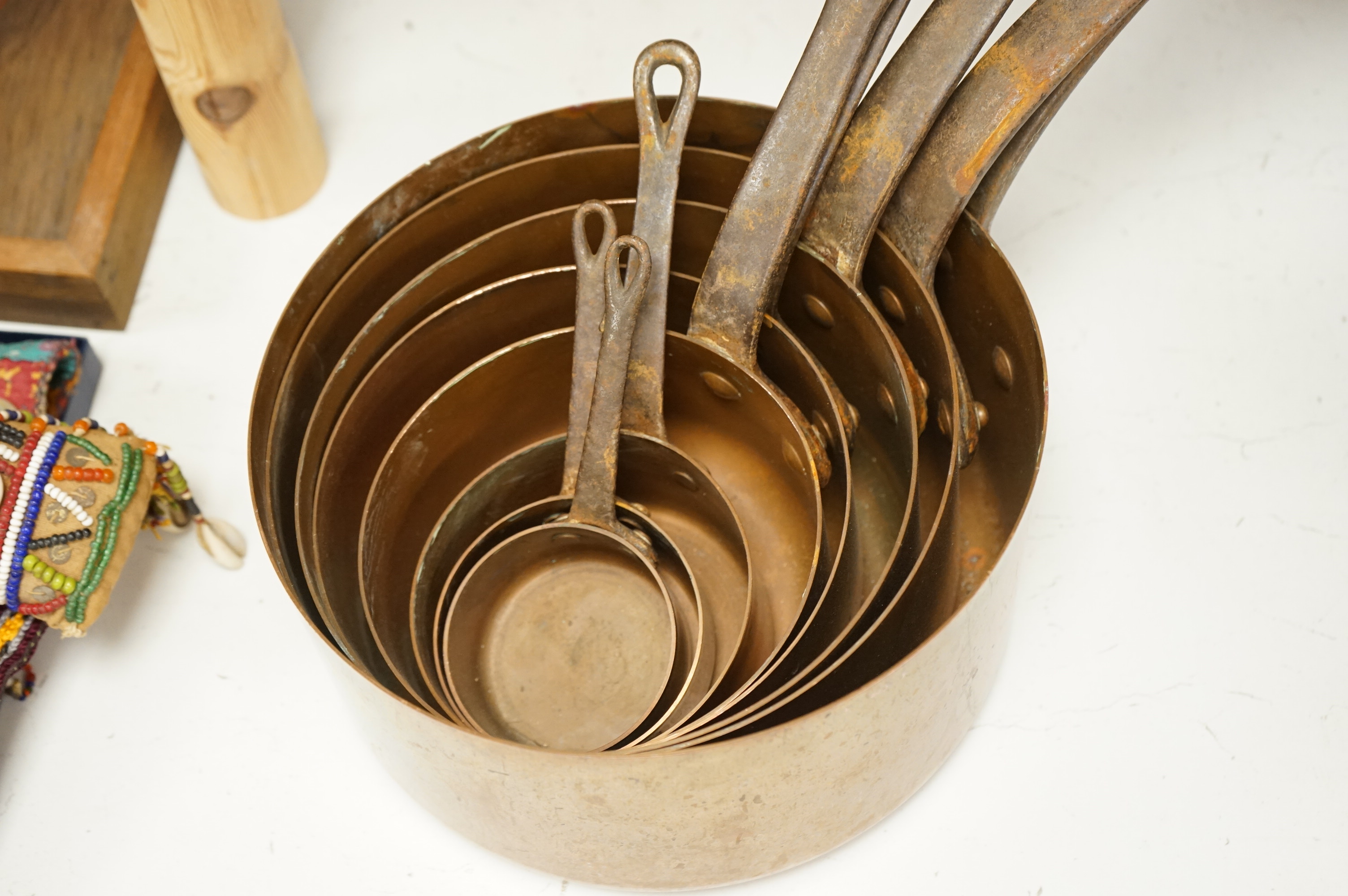 A graduated set of copper saucepans, largest 20.5cm diameter, smallest 6.5cm